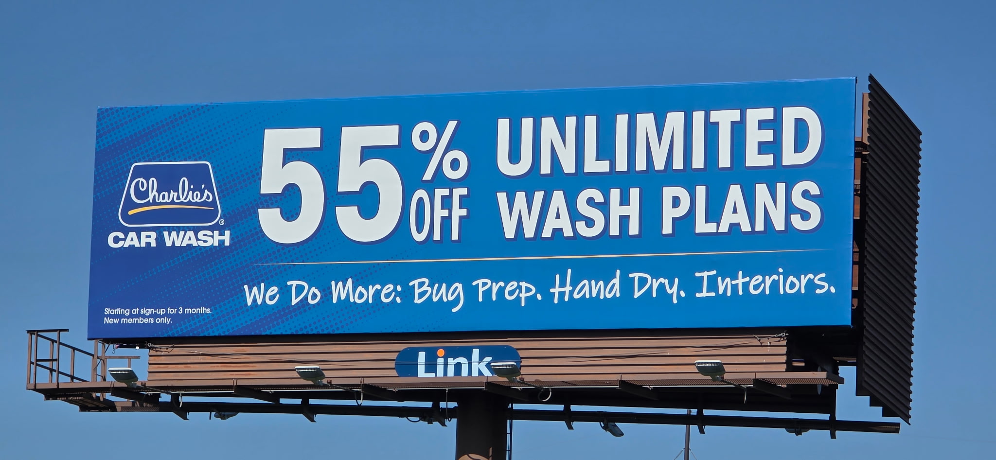 Charlie's Car Wash billboard promoting 55% off unlimited wash plans