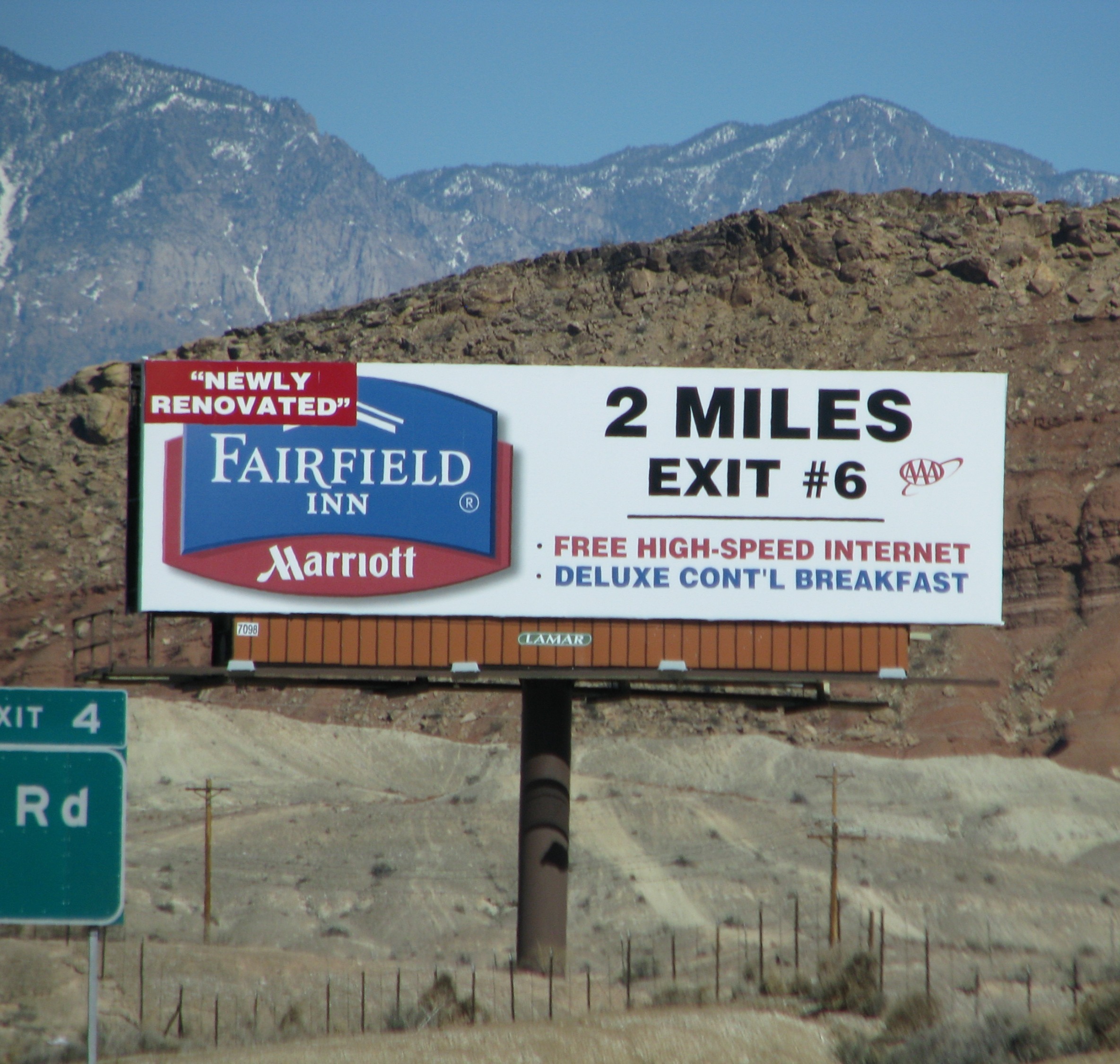 Fairfield Inn by Marriott billboard beside the interstate, snow-capped mountains behind it